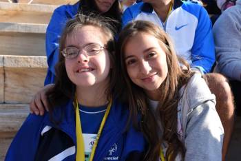 A girl and Special Olympic Hellas athlete hug and smile